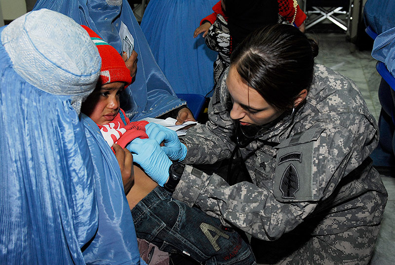 Photo: A medic with Combined Joint Special Operations Task Force in Afghanistan listens to the heartbeat of a small boy at the free clinic at Bagram Airfield’s Korean Hospital